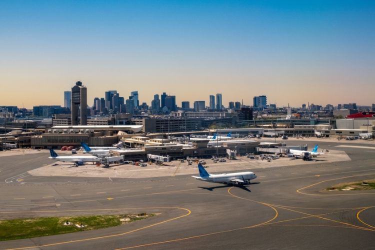 A view of Logan International Airport terminals and runway at sunset
