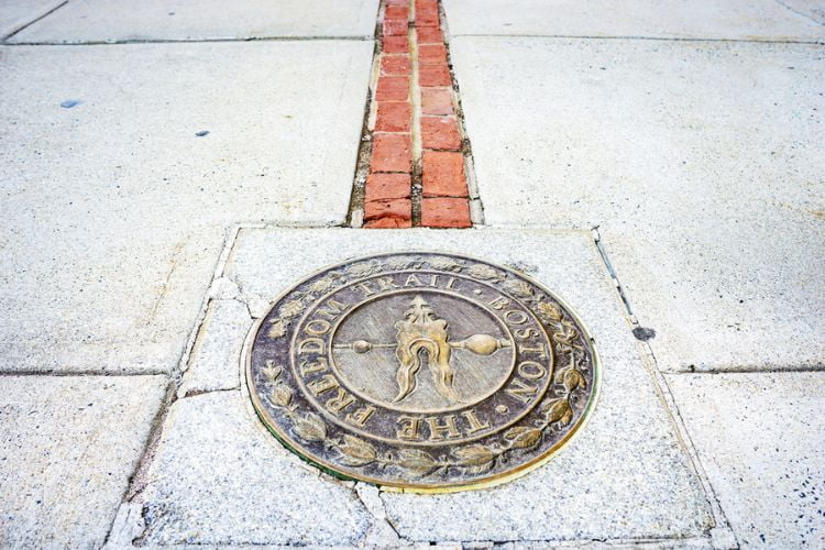 A marker on the red brick Freedom Trail in Boston